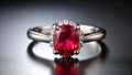 Elegant silver ring with a vibrant red ruby gemstone and diamond halo on a reflective surface Royalty Free Stock Photo