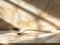 Elegant silver spoon on marble surface sunlit Royalty Free Stock Photo