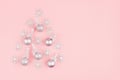 Elegant simple Christmas tree of silver glittering balls with ribbon and snowflakes on pastel pink backdrop, top view, copy space. Royalty Free Stock Photo