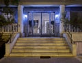 An elegant sixties apartment building`s main entrance, with marble stairs and a framed glass door Royalty Free Stock Photo