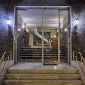 An elegant sixties apartment building`s main entrance, with marble stairs and a framed glass door Royalty Free Stock Photo