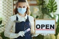 Elegant small business owner woman in apron showing open sign Royalty Free Stock Photo