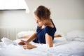 Elegant, smart, young woman using her tablet computer in bed Royalty Free Stock Photo