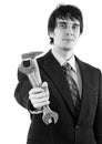 Elegant smiling businessman handing out hammer and wrench