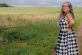 Elegant smiling senior adult woman wearing black and white sundress standing in field Royalty Free Stock Photo