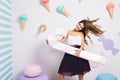 Elegant smiling sweet-tooth girl spending time on wedding party and holding big toy lollipop. Portrait of pleased young Royalty Free Stock Photo