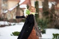 Elegant smiling young woman with long blonde hair in a black coat poses in the city. Portrait of a beautiful modern woman with Royalty Free Stock Photo