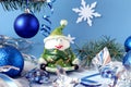 Elegant snowman among Christmas balls and Christmas tinsel on a blue background, side view Royalty Free Stock Photo