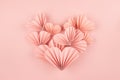 Elegant soft pink paper ribbed heart shape of little hearts in oriental origami style as soar flow on pink background, top view. Royalty Free Stock Photo