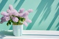 Elegant spring still life with lilacs in a pastel-hued interior. Minimalistic decor featuring a vase of delicate blossoms