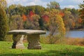 Elegant stone bench with view to autumn forest and lake Royalty Free Stock Photo