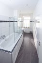 elegant stylish bathroom hotel home white tiles grey floor tub shower backlight window Royalty Free Stock Photo