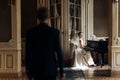 elegant stylish handsome groom looking at his gorgeous bride playing the piano. reflection in the mirror. unusual luxury wedding Royalty Free Stock Photo