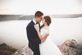 Elegant stylish happy wedding couple, bride, gorgeous groom on the background of sea and sky Royalty Free Stock Photo