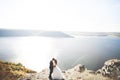 Elegant stylish happy wedding couple, bride, gorgeous groom on the background of sea and sky Royalty Free Stock Photo