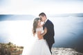 Elegant stylish happy wedding couple, bride, gorgeous groom on the background of sea and sky Royalty Free Stock Photo