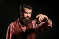 Elegant and stylish man in classical wear holding glass with whiskey in hand.