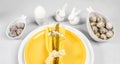 Elegant stylish serving of Easter table in white yellow colors with plates, eggs, ceramic bunnies. Royalty Free Stock Photo