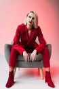 elegant stylish woman in red clothes posing in armchair, Royalty Free Stock Photo