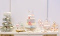 Elegant sweet table with big cake, cupcakes, cake pops on dinner