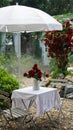 Beautiful serving table outdoor festive holiday with a bouquet roses in a vase. Cottage core yard decorated for a party