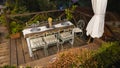 Elegant table set for dinner on the terrace garden, placemat on the table, wine glasses, dried flowers in a glass jug as a decor. Royalty Free Stock Photo