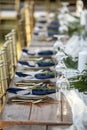 Elegant table set up for outdoor wedding reception with fine china and blue napkins Royalty Free Stock Photo