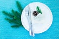 Elegant table setting for a Christmas dinner. Plates and gift box on a light blue background. Royalty Free Stock Photo