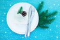 Elegant table setting for a Christmas dinner. Plates and gift box on a light blue background. Royalty Free Stock Photo