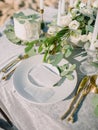 Elegant table setting with a paper card decorated with eucalyptus branches. Romantic table with paper invitation card. Wedding Royalty Free Stock Photo