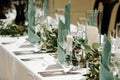 Elegant table setting at the restaurant. Wedding banquet with floral decoration on table, cards, glasses and cutlery