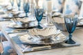 elegant table with silver shell bowls, coralprint chair covers, and blue stemware