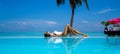 Elegant tanned woman in white swimsuit in pool on tropical Maldives island. Beautiful bikini body girl in pool with view on Royalty Free Stock Photo