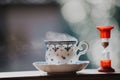 Elegant tea cup and hourglass stand shelf Royalty Free Stock Photo