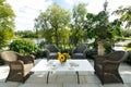 Elegant tea serving in garden with sunflowers in vase on marble table with silver tea pot and cookies