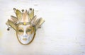 Elegant traditional venetian mask over distressed old white wooden background