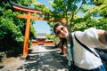 Elegant traveler standing in front of the Torii