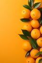 Fresh oranges with leaves on orange colored background, empty copy space, Vertical format 2:3