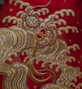 elegant and vibrant red silk fabric with an anchor and waves embroidery texture background close up from a kimono dress