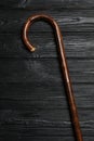 Elegant walking cane on black wooden table, top view