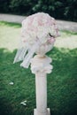 Elegant wedding bouquet on column, stylish decor of wedding aisle outdoors. Pink and white roses arrangement at wedding reception Royalty Free Stock Photo