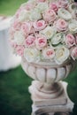 Elegant wedding bouquet on column, stylish decor of wedding aisle outdoors. Pink and white roses arrangement at wedding reception Royalty Free Stock Photo