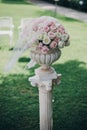 Elegant wedding bouquet on column, stylish decor of wedding aisle outdoors. Pink and white roses arrangement at wedding reception Royalty Free Stock Photo