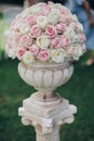 Elegant wedding bouquet on column, stylish decor of wedding aisle outdoors. Pink and white roses arrangement at wedding reception Royalty Free Stock Photo