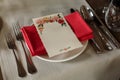 Elegant wedding menub reception catering, luxury table arrangement - floral greeting card on red napkin near expensive silverware Royalty Free Stock Photo