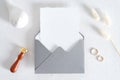 Elegant wedding stationery mockup scene. Blank invitation card, grey envelope with wax seal stamp, dried flowers, golden rings on Royalty Free Stock Photo