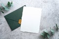 Elegant wedding stationery set. Wedding invitation card template and green envelope on concrete background. Flat lay, top view, Royalty Free Stock Photo