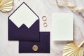 Elegant wedding stationery set top view. Flat lay blank invitation card mockup, purple envelopes on stone desk