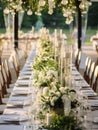 Elegant wedding table decoration with many candles and flowers, predominantly white color