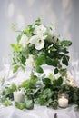 Elegant wedding table decoration with many candles and flowers, predominantly white color